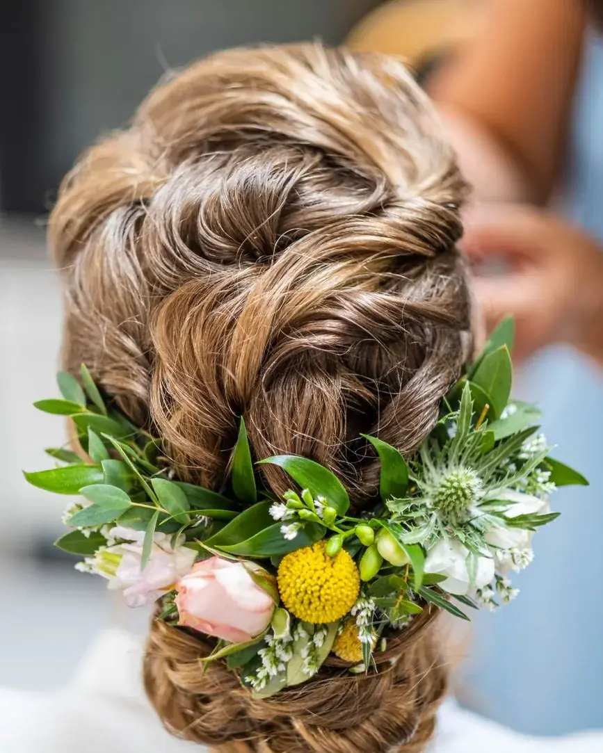 Chignon ondulé orné de fleurs fraîches, vu de dos