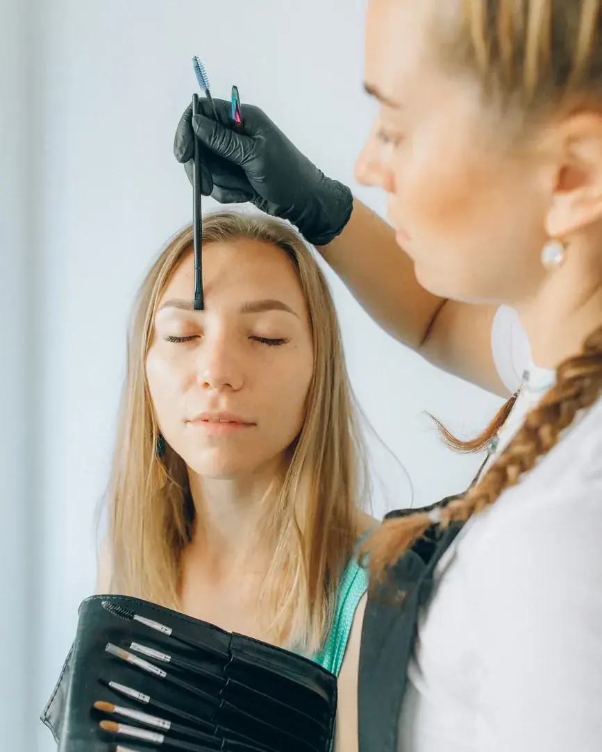 Tracé des repères du sourcil avant un microblading, gants noirs