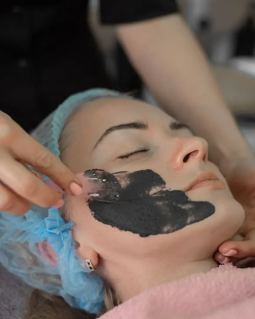 Application d'un masque noir au pinceau pendant un soin du visage