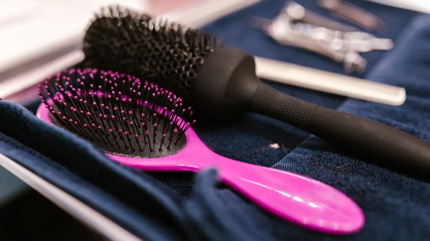 Brosses de coiffure disposées sur une serviette propre avant un brushing